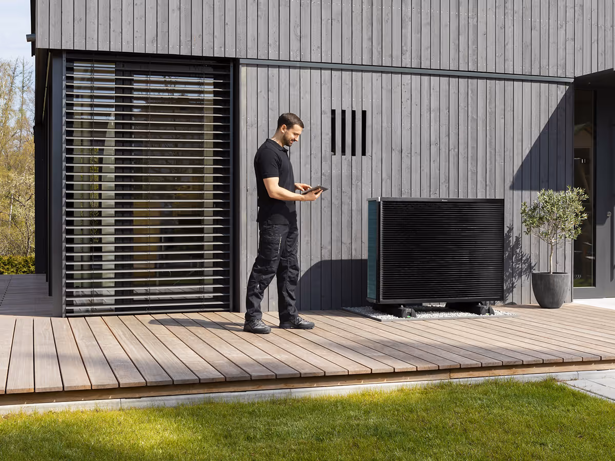 Technik u venkovní jednotky tepelného čerpadla Daikin u moderního rodinného domu